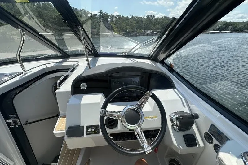 Slide: The Image of 2019 Regal 35 Sport Coupe helm with steering wheel and dashboard, overlooking serene waters. - 9