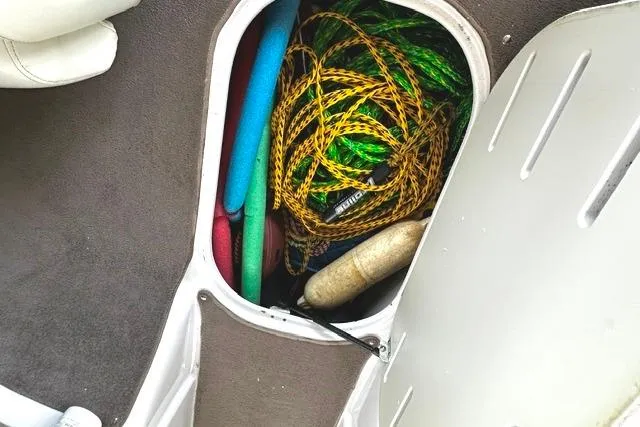 Slide: The Image of Storage compartment in 2007 Four Winns 200 Horizon boat with ropes and pool noodles. - 19