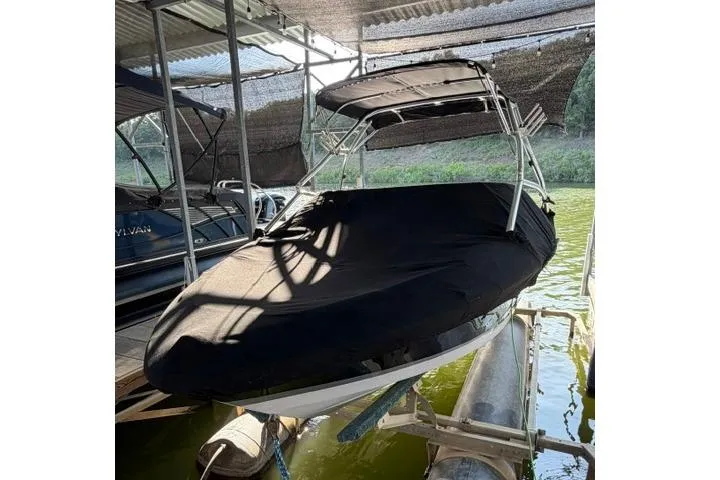 Slide: The Image of 2007 Four Winns 200 Horizon boat covered and docked in a shaded area. - 20