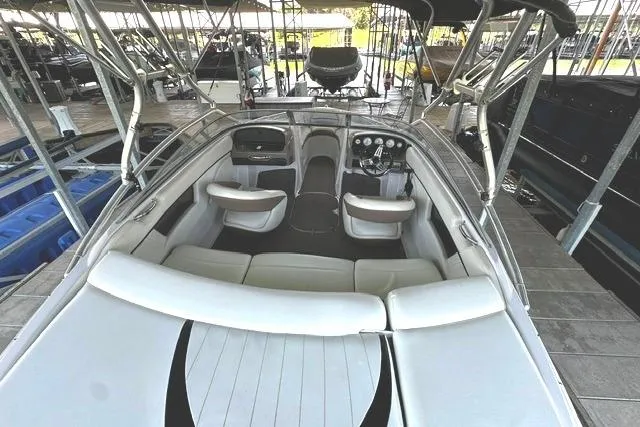 Slide: The Image of 2007 Four Winns 200 Horizon boat interior with seating and dashboard in a marina. - 7