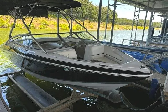 Slide: The Image of 2007 Four Winns 200 Horizon boat docked on a lift by a scenic lake. - 1