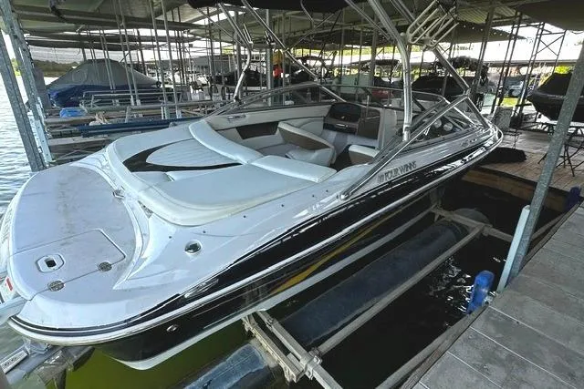 Slide: The Image of 2007 Four Winns 200 Horizon boat docked in a marina, featuring sleek design and spacious seating. - 2