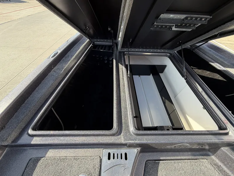 Slide: The Image of The image shows the storage compartments of a 2018 Falcon F205 boat. The lids are open. - 26