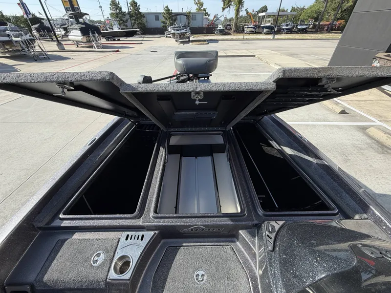 Slide: The Image of The image shows the open storage compartment of a 2018 Falcon F205 boat in a parking lot. - 27