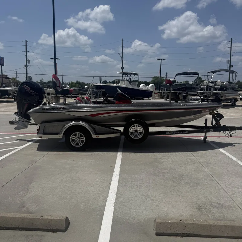 Slide: The Image of A 2019 Ranger Z518 boat on a trailer in a parking lot. It features a sleek design. - 7