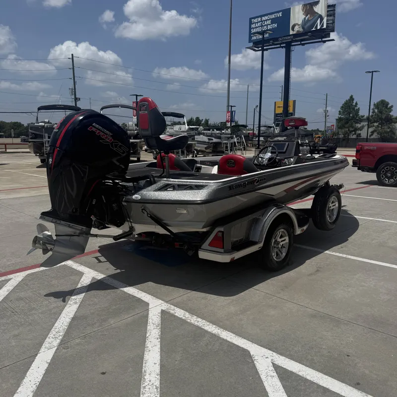 Slide: The Image of A 2019 Ranger Z518 boat on a trailer in a parking lot. It features a large outboard motor. - 8