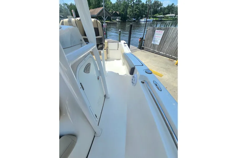 Slide: The Image of 2019 Tidewater 210 LXF boat interior, featuring sleek design and spacious seating by the water. - 24