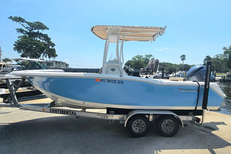 Slide: The Image of 2019 Tidewater 210 LXF boat on trailer, blue hull, parked near water. - 10