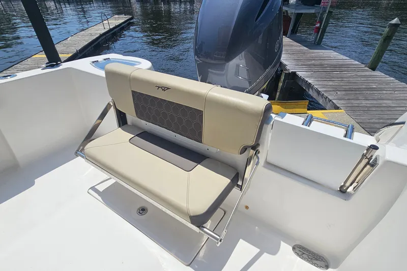 Slide: The Image of 2019 Tidewater 210 LXF boat interior with beige seating and docked engine view. - 16