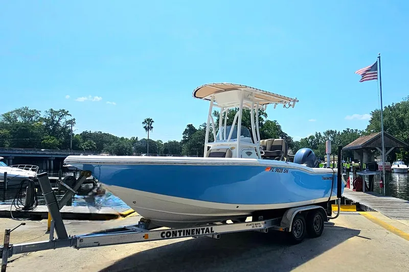 Slide: The Image of 2019 Tidewater 210 LXF boat on trailer at marina with American flag. - 11