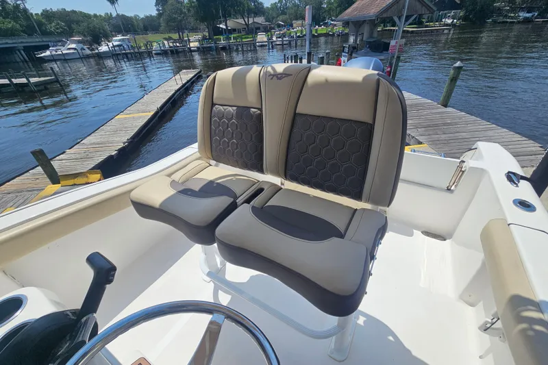 Slide: The Image of 2019 Tidewater 210 LXF boat interior with dual seats at a dockside location. - 14