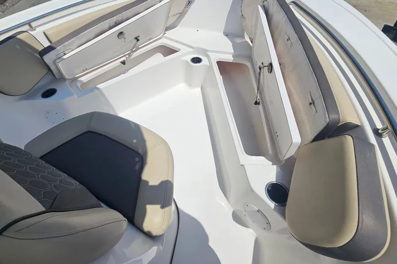 Slide: The Image of 2019 Tidewater 210 LXF boat interior with open storage compartments and cushioned seating. - 22