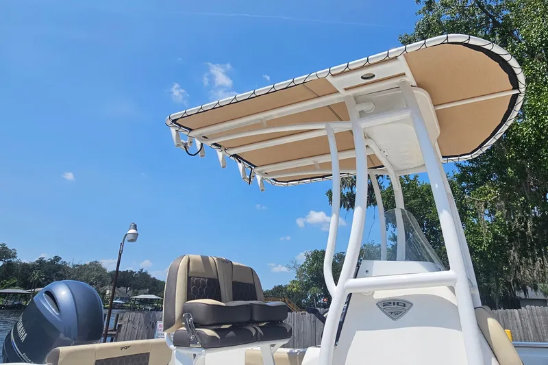 Slide: The Image of 2019 Tidewater 210 LXF boat with T-top and seating, under a clear blue sky. - 3
