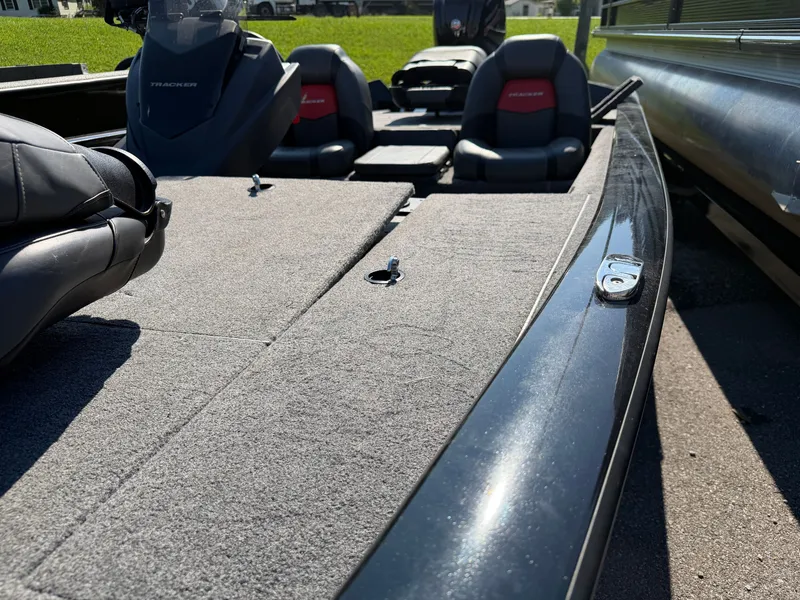 Slide: The Image of The image shows the deck of a 2025 Tracker Pro Team 190 boat with gray carpeting. - 14
