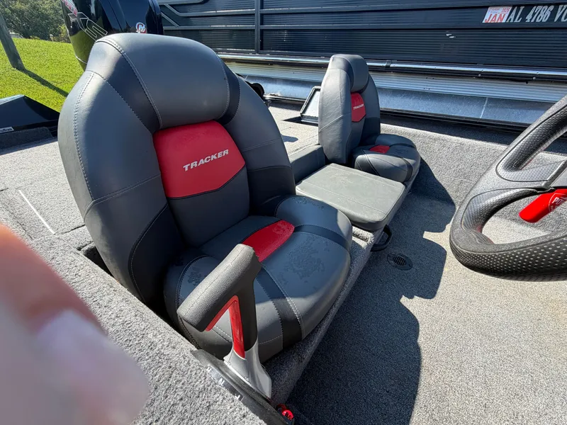 Slide: The Image of Two cushioned seats in a boat with gray carpeting and red accents. - 19