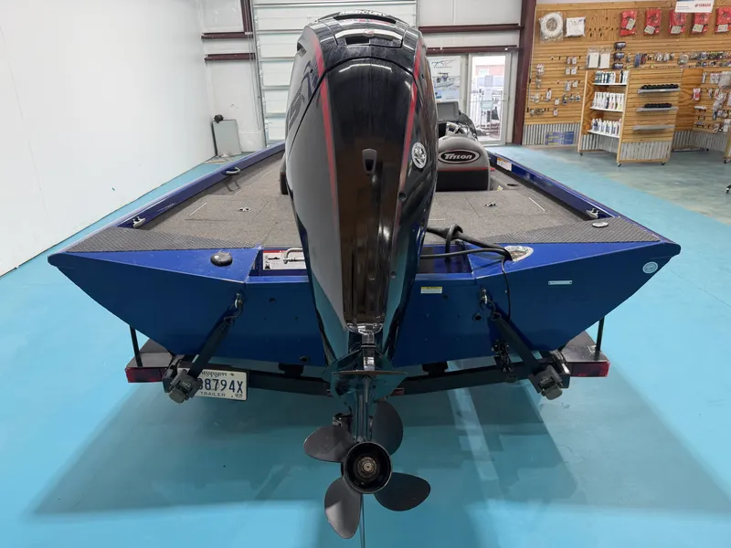 Slide: The Image of A blue 2017 Triton 18CTX with an outboard motor in a showroom. - 10