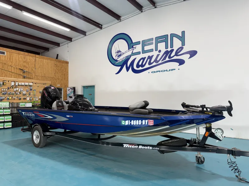 Slide: The Image of A blue 2017 Triton 18CTX is in a showroom. It features an outboard motor. - 3