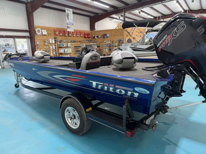 Slide: The Image of A blue 2017 Triton 18CTX in a showroom. It features two seats and a Mercury engine. - 9