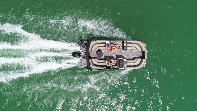The Image of Aerial view of a Viaggio x22u pontoon boat on green water with two people aboard. - 1