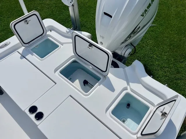 Slide: The Image of The image shows the stern of a Sportsman Masters 267 Bay Boat with open storage compartments and an outboard motor. - 19