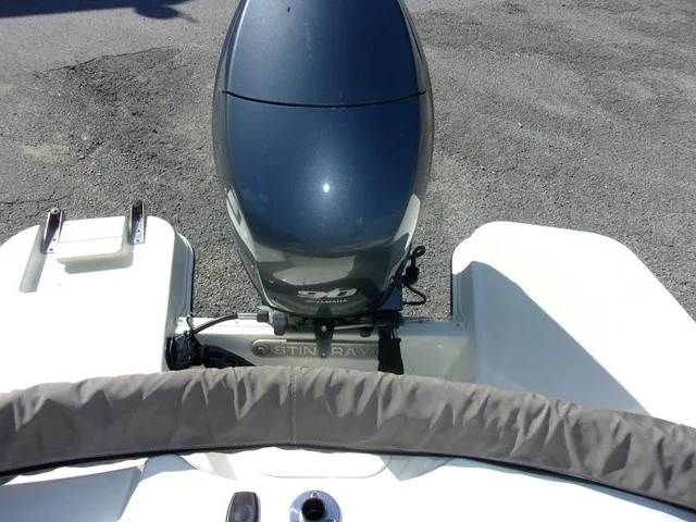 Slide: The Image of An outboard motor on a white boat, resting on a gravel surface. The motor is dark gray. - 6