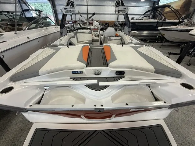 Slide: The Image of The image shows the stern of a 2017 Tigé Z3 boat in a showroom. It features gray and orange upholstery. - 31
