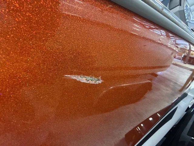 Slide: The Image of Close-up of an orange boat hull with a scratch. - 34