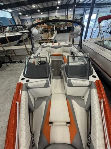 Slide: The Image of The image shows a 2017 Tigé Z3 boat with orange and white upholstery in a showroom. - 16