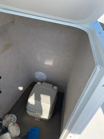 Slide: The Image of A compact toilet area with a portable toilet and cleaning supplies. - 7