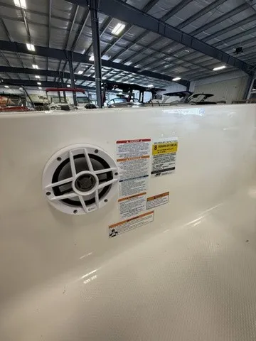 Slide: The Image of A speaker is mounted in the white interior wall of a boat, surrounded by warning labels. - 20