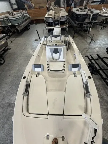 Slide: The Image of A 2023 Robalo 206 Cayman boat in a showroom, featuring white seating and a helm station. - 24