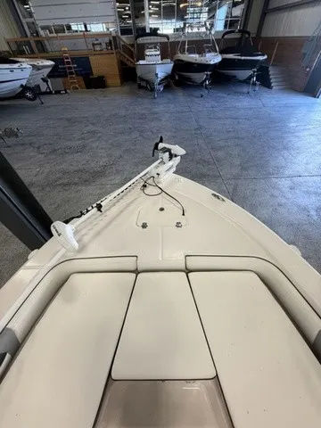 Slide: The Image of The image shows the bow of a 2023 Robalo 206 Cayman boat in a storage facility. - 23