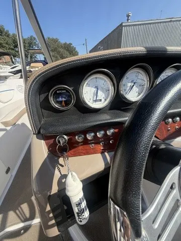 Slide: The Image of The dashboard of a boat with multiple gauges and a steering wheel. - 17