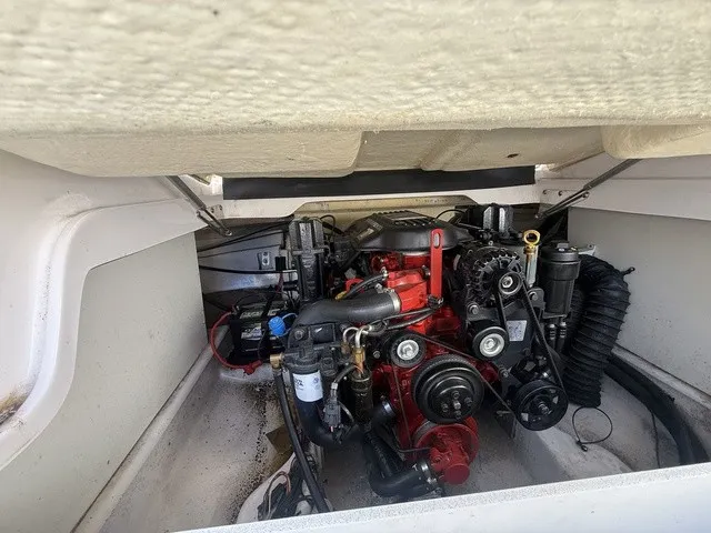 Slide: The Image of An engine compartment with a red engine in a boat, surrounded by white walls. - 36