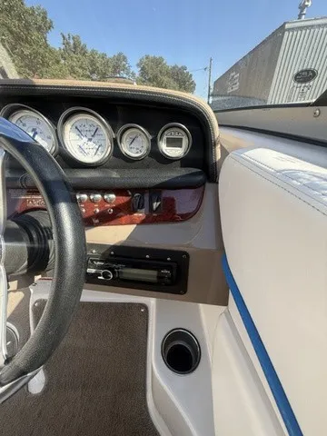 Slide: The Image of The image shows a boat dashboard with multiple gauges and a steering wheel. - 21