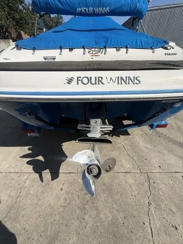 Slide: The Image of The image shows the stern of a blue 2008 Four Winns H220 boat on a concrete surface. - 16