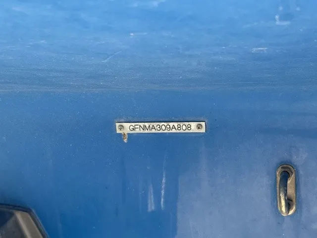Slide: The Image of Close-up of a blue boat hull with a serial number and a metal hook. - 38