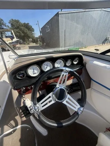 Slide: The Image of The image shows the cockpit of a 2008 Four Winns H220 with a sleek steering wheel and gauges. - 20