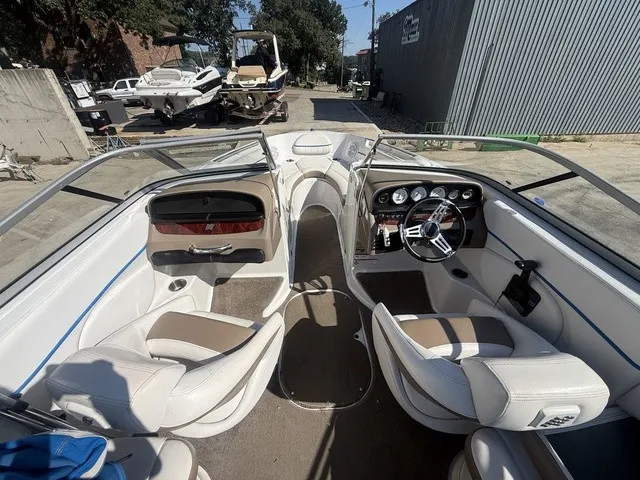 Slide: The Image of Interior view of a 2008 Four Winns H220 with white and brown seats and a modern dashboard. - 30