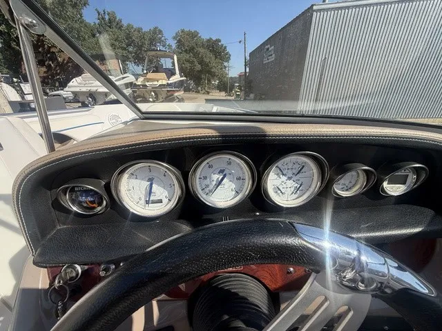 Slide: The Image of The dashboard of a 2008 Four Winns H220 with multiple gauges and a steering wheel. - 22
