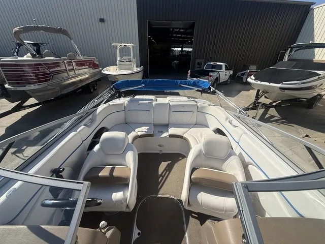 Slide: The Image of A 2008 Four Winns H220 boat with white and beige interior, parked in a warehouse. - 27