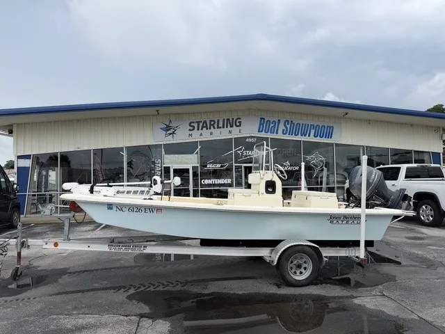 The Image of A 2022 Jones Brothers Bateau 17 on a trailer in front of a boat showroom. - 1