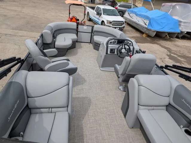 Slide: The Image of The image shows the spacious deck of a South Bay S222RS 25" pontoon boat with gray upholstery. - 3