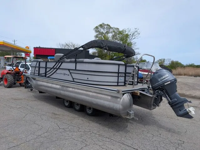Slide: The Image of A 2024 South Bay S222RS pontoon boat with a Yamaha outboard motor, parked on a trailer. - 2