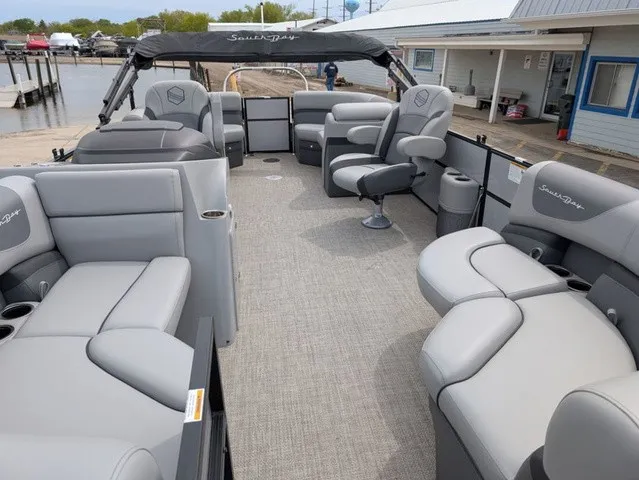 Slide: The Image of The image shows a 2024 South Bay S222RS 25" pontoon boat with gray upholstery and a spacious deck. - 6