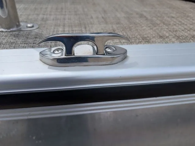 Slide: The Image of Close-up of a boat deck with a silver cleat fitting on a textured surface. - 9