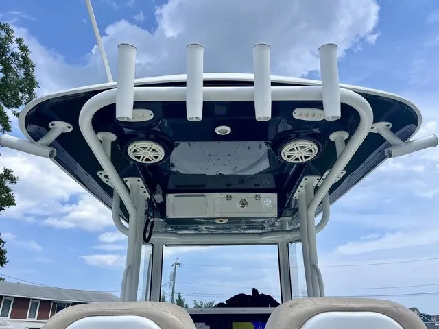 Slide: The Image of The image shows the T-top of a 2020 Sportsman Masters 267 Bay Boat with speakers and rod holders. - 15