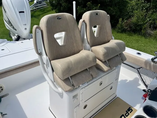 Slide: The Image of Two beige cushioned seats on a white boat with a green background. - 14