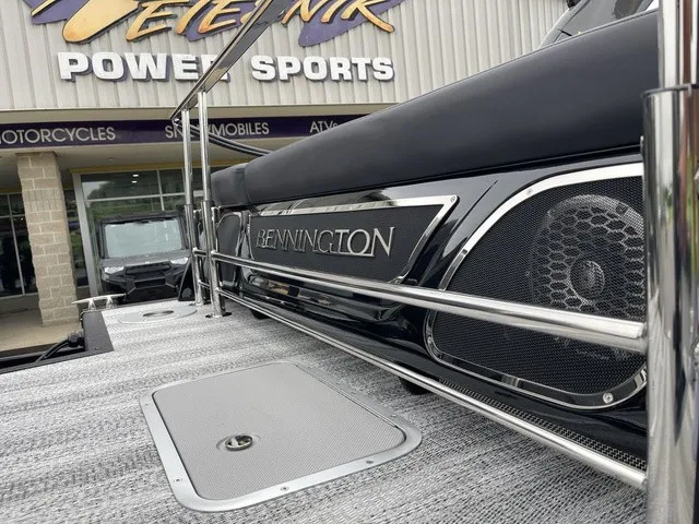 Slide: The Image of Close-up of a Bennington boat with speakers and metal railing, in front of a sports store. - 30