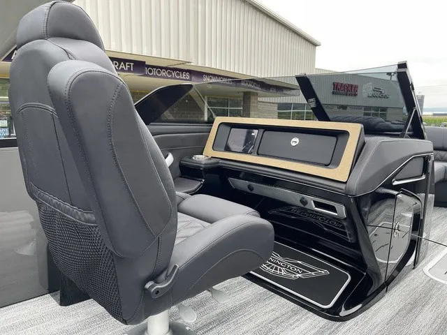 Slide: The Image of The image shows the helm of a Bennington QX Swingback 27 QXSBWAT2 with a cushioned seat and modern controls. - 23